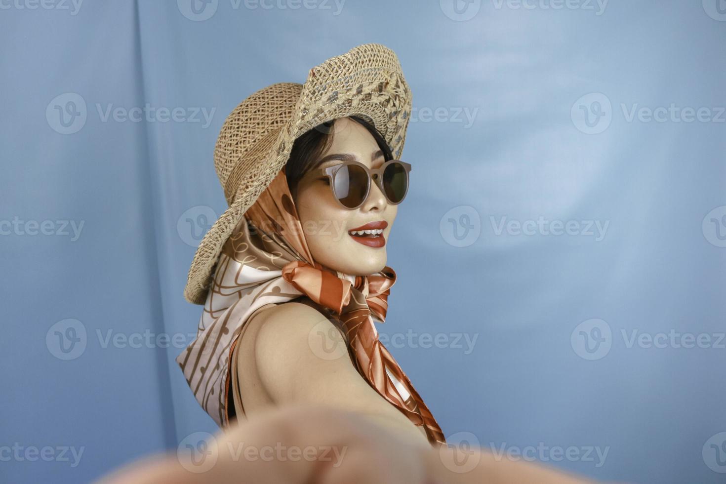 reizend concept van een jonge Aziatische vrouw die een selfie neemt geïsoleerd door een blauwe achtergrond foto