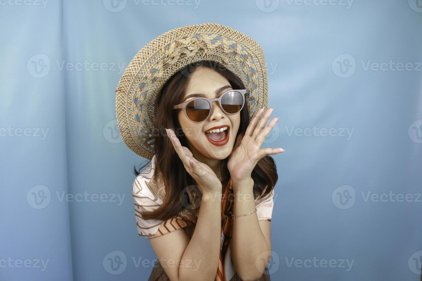 jonge Aziatische geschokte vrouw schreeuwt geïsoleerd door een blauwe achtergrond. foto