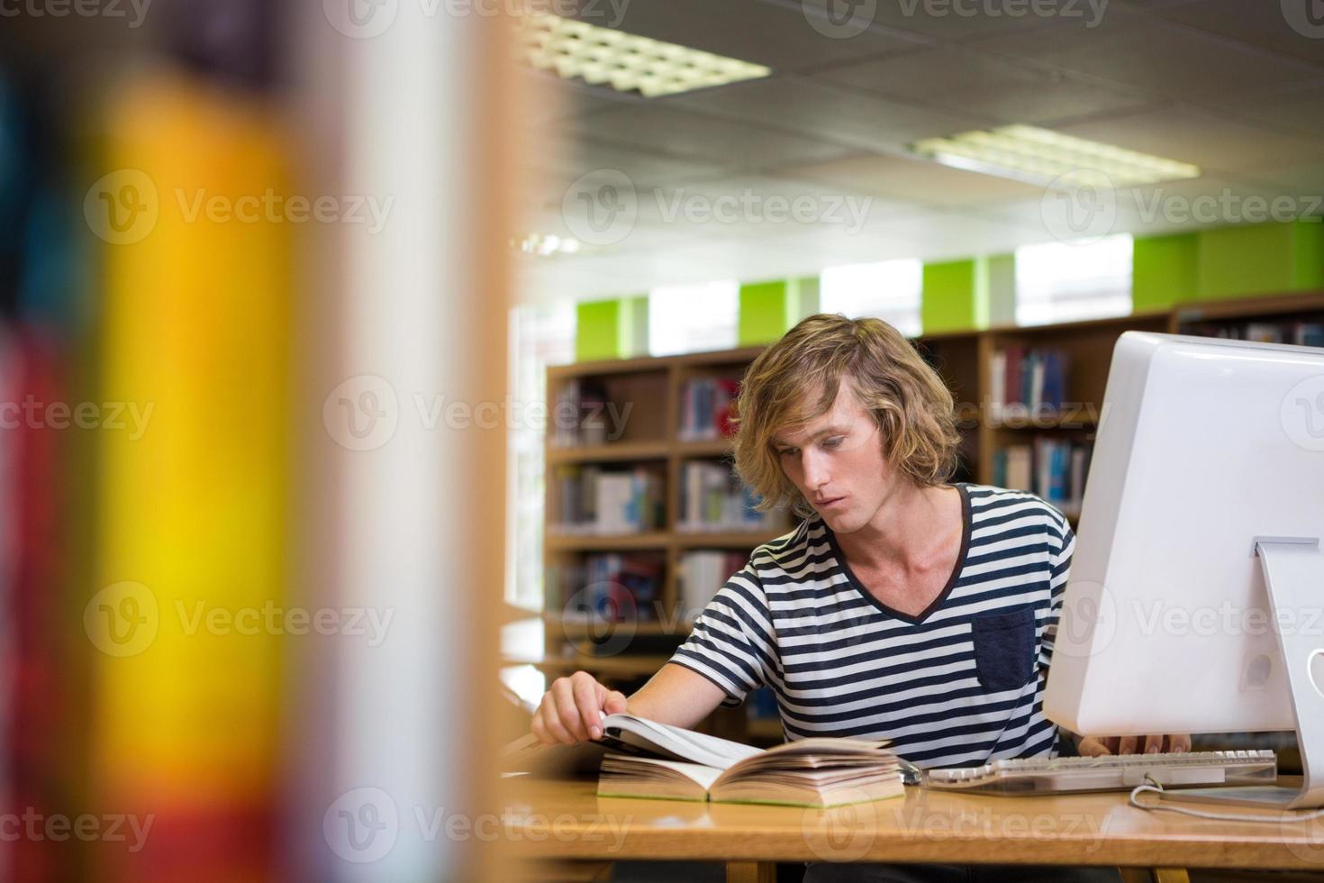 student studeert in de bibliotheek met computer foto
