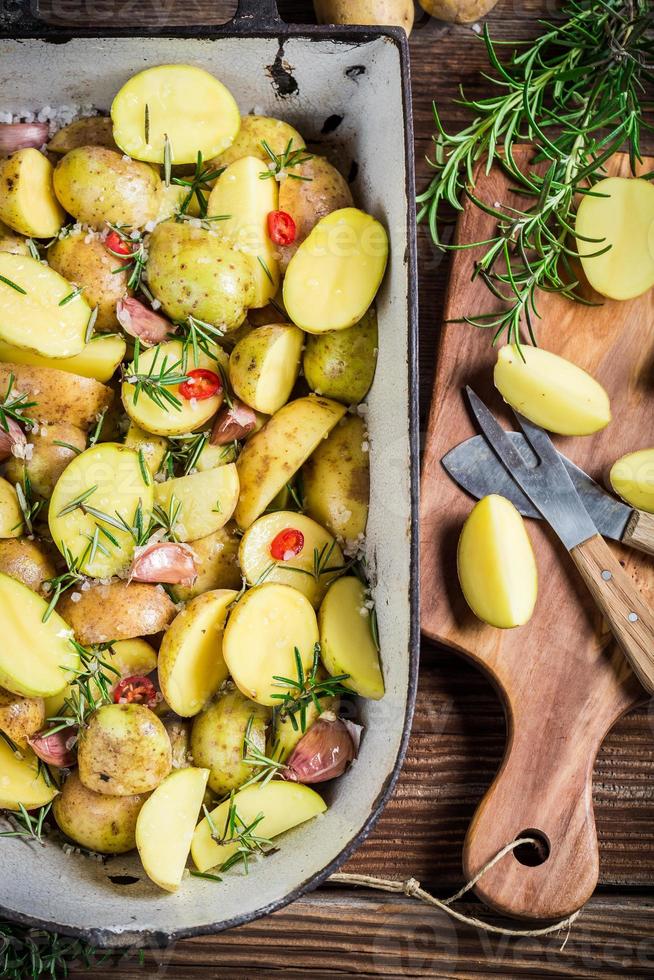 het bereiden van gebakken aardappelen met kruiden en knoflook foto