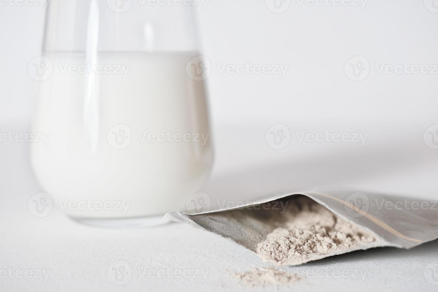 collageenpoeder reispakket en een glas melk om een eiwitcocktail te maken. collageenpeptidenpoeder voor een gezonde milkshake. gewrichten zorg en voeding voor een mooie huid. foto