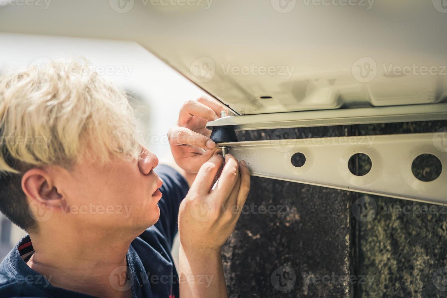 een professionele elektricien man repareert rubberen schokdemper trillingsisolatoren voor airconditioners om laagfrequent geluid veroorzaakt door trillingen te verminderen foto