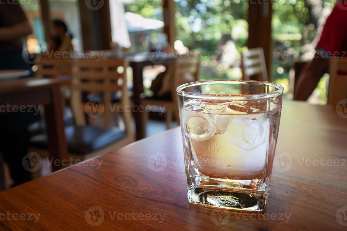 glas water op houten tafel in restaurant foto