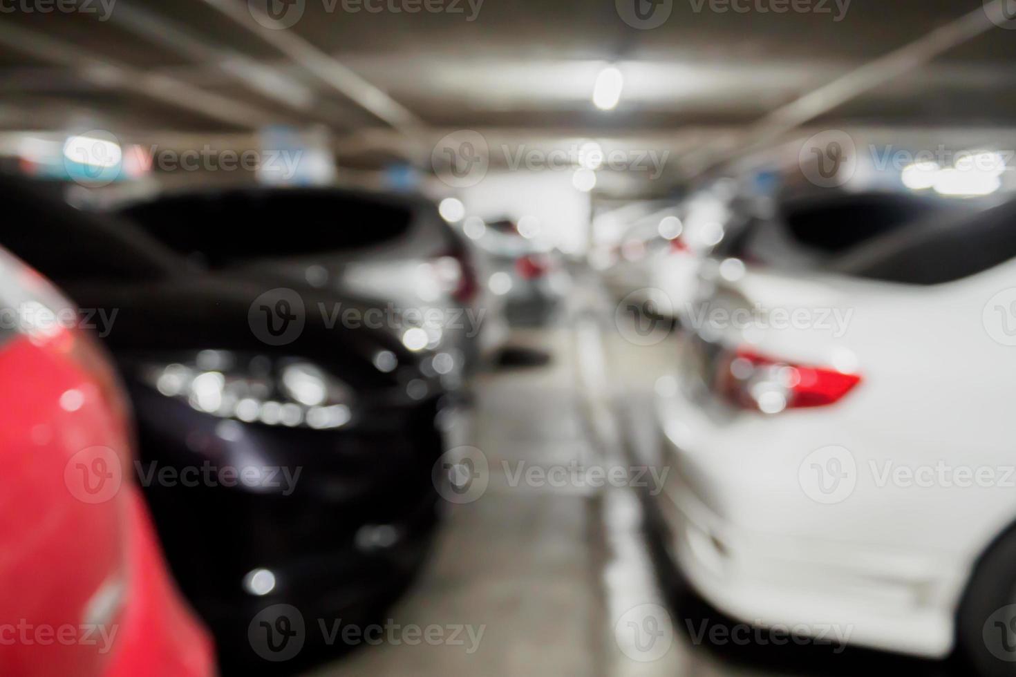 vervaag veel auto's op de parkeerplaats in het winkelcentrumgebouw foto