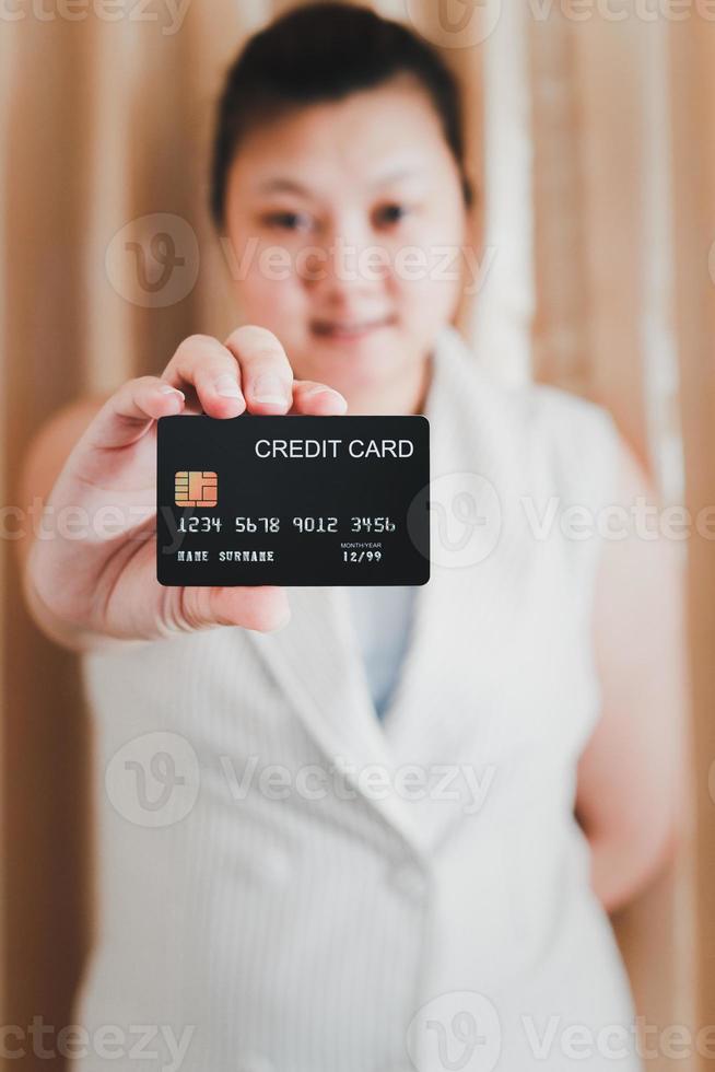 de rechterhand van een blanke vrouw die een mock-up creditcard toont om te winkelen. selectieve aandacht. foto