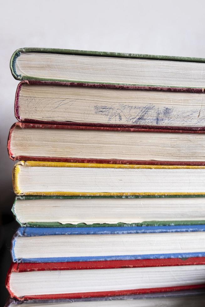 stapel kleurrijke oude boeken op witte achtergrond. close-up rij boeken met veroudering van de pagina's. verticaal formaat. foto