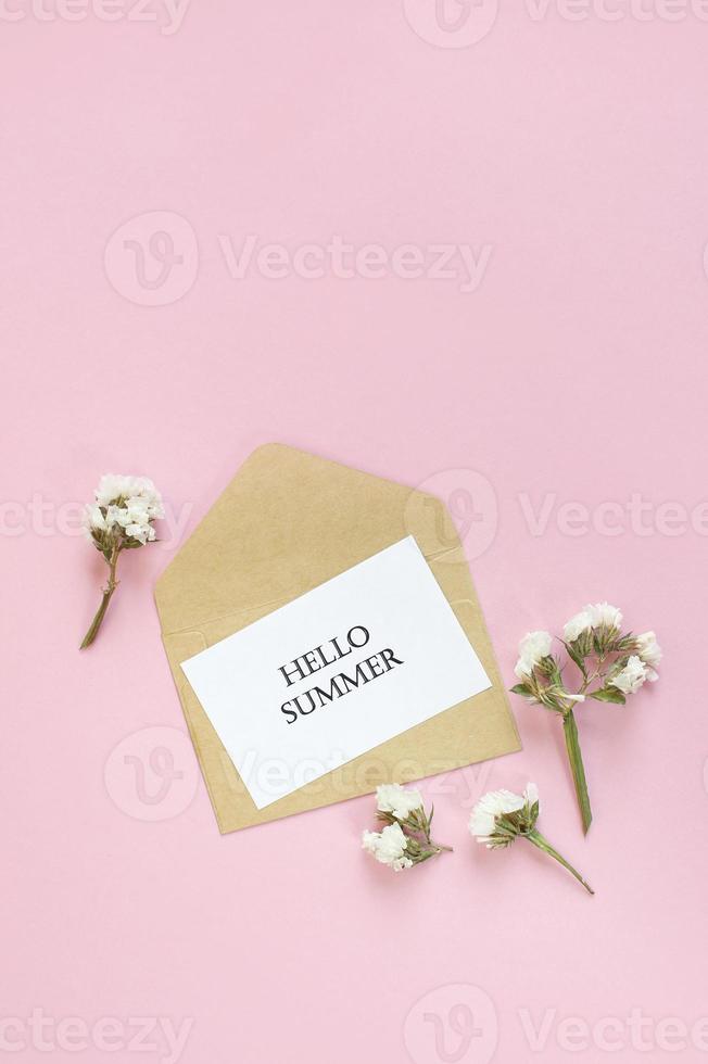 Hallo zomer. brieven zomer en bloemen op roze achtergrond. lege kaart met kopie ruimte. foto