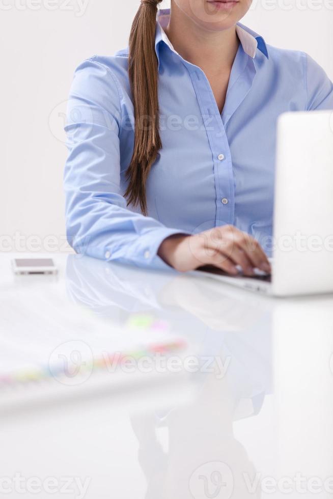 vergrote weergave van mooie vrouw met laptop aan balie foto
