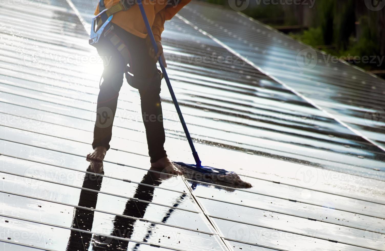 fotovoltaïsche technici waren bezig met het schoonmaken en wassen van het oppervlak van de zonnepanelen met stof en vogelpoep foto