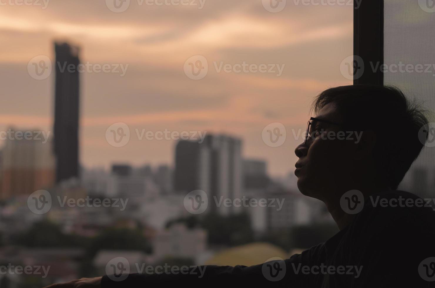 de man die vanuit de kamer uitkijkt op het uitzicht op de stad. foto