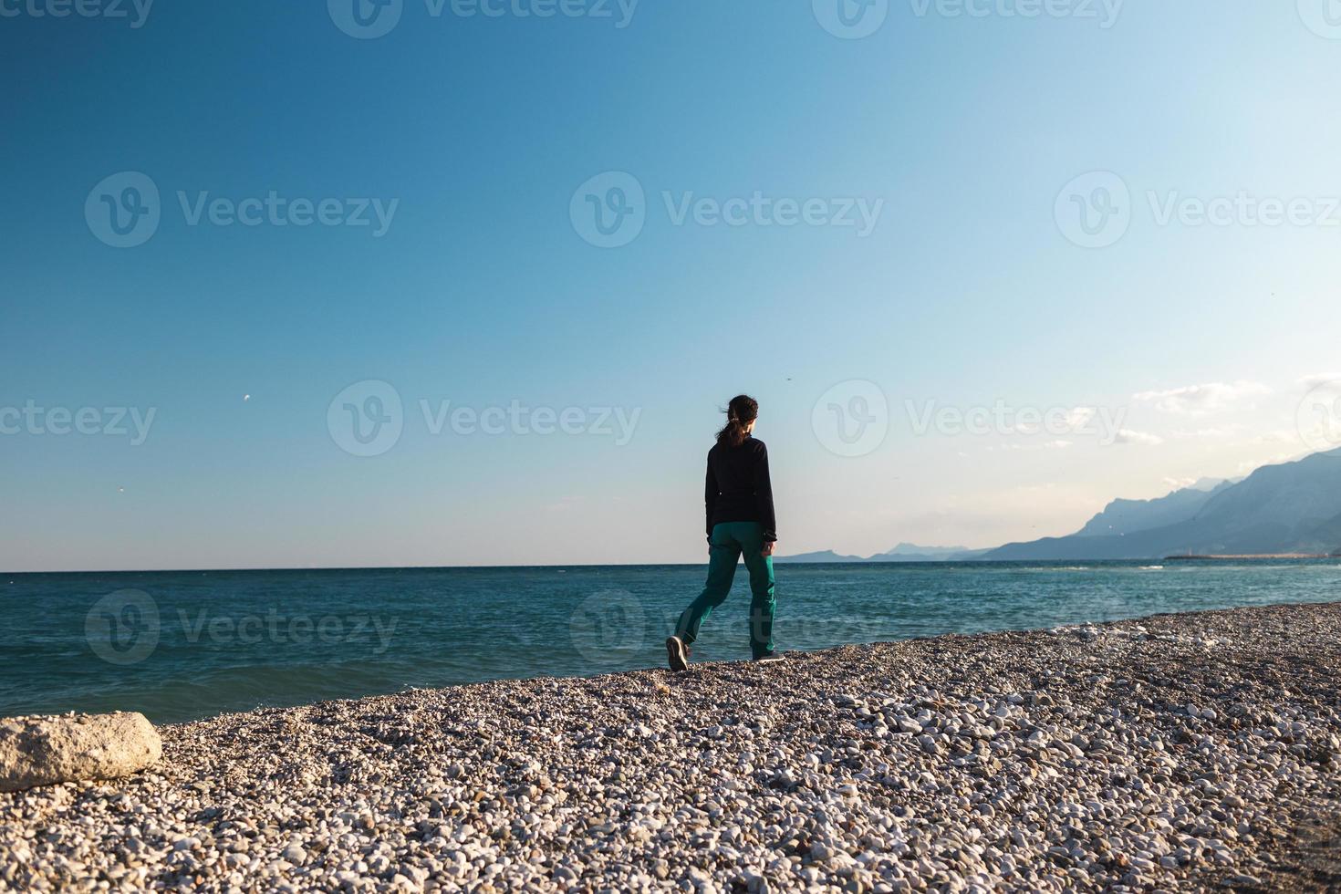 een meisje loopt alleen langs het strand foto