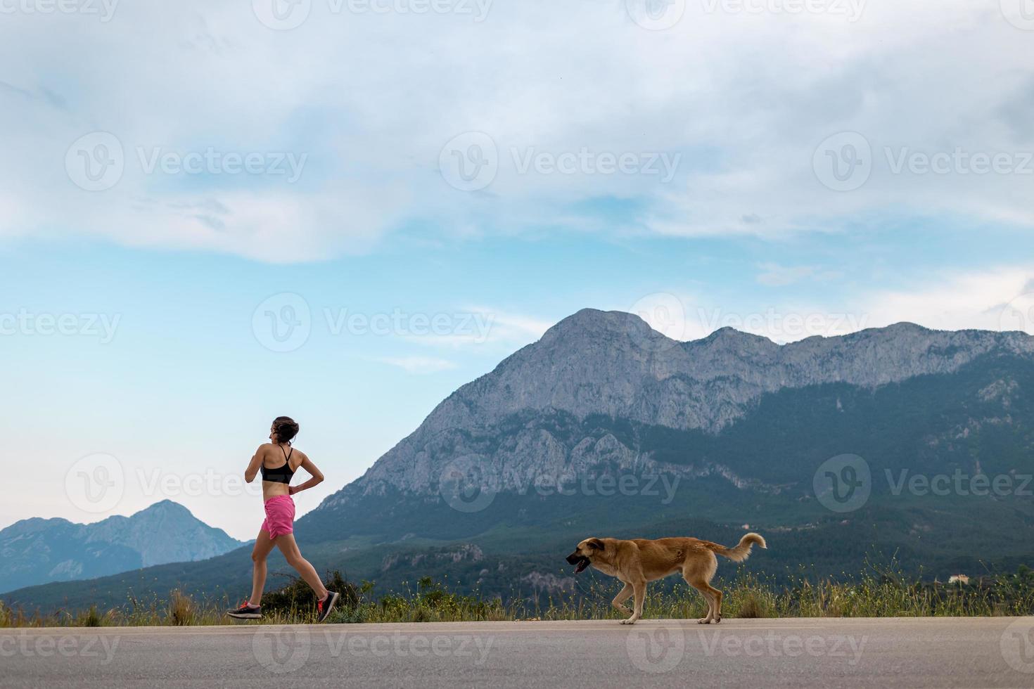 een vrouw die 's avonds jogt met een hond foto
