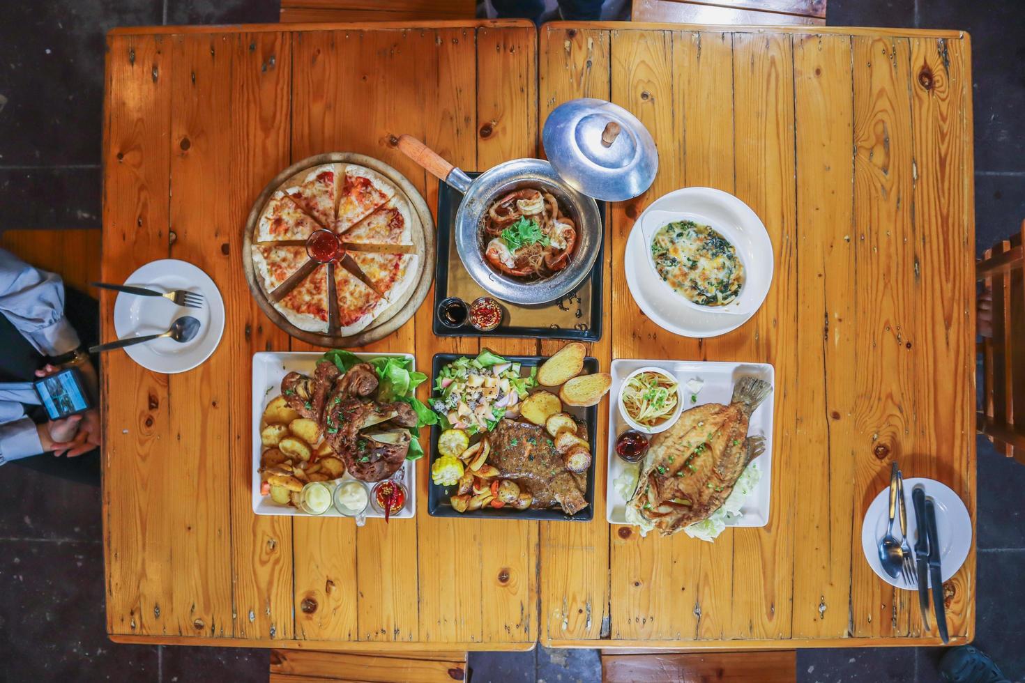 een verscheidenheid aan gerechten staat op tafel om familie- en vriendenbanketten op oudejaarsavond voor te bereiden. diverse ideeën voor het bereiden van voedsel voor familie- en vriendenfeesten tijdens de feestdagen. foto