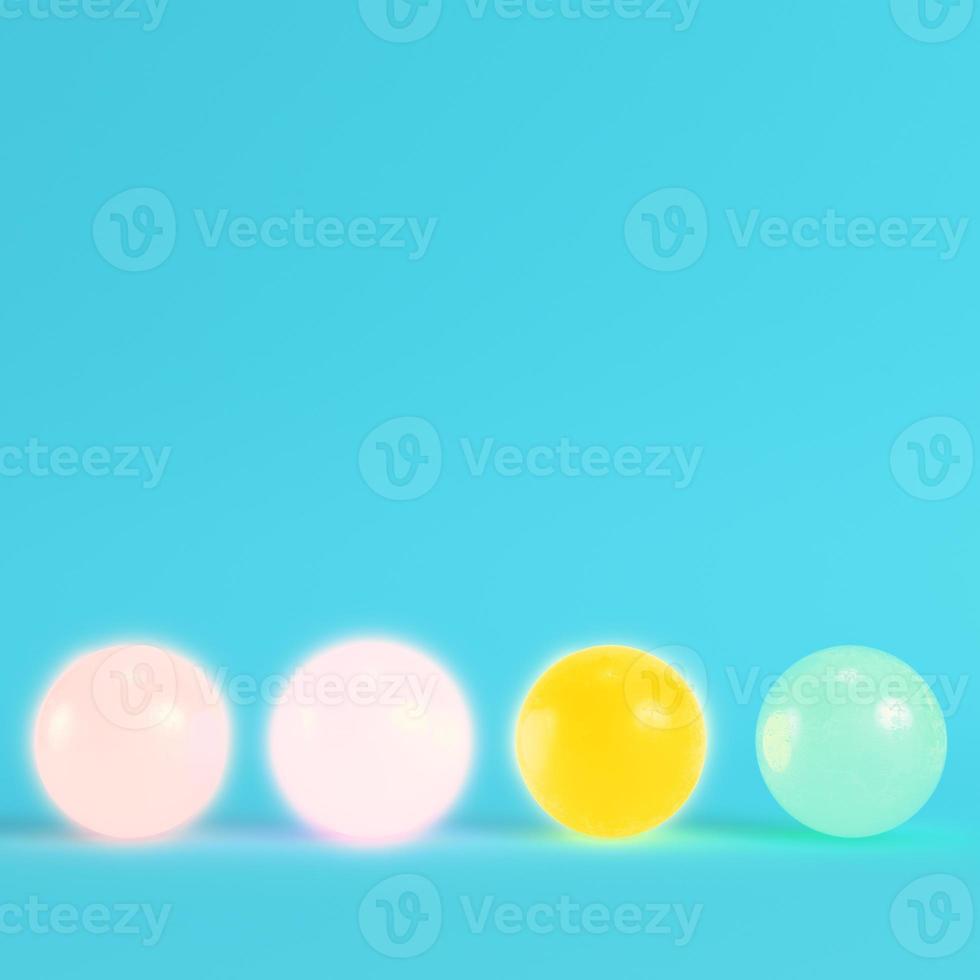 vier kleurrijke kristallen bollen op helderblauwe achtergrond in pastelkleuren. foto