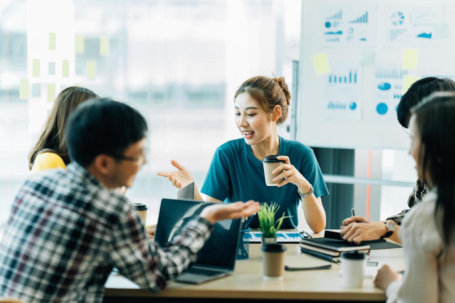 jonge aziatische vrouw leidt zakelijk creatief team in ontwerpproject voor mobiele applicatiesoftware. brainstormvergadering, samenwerken, internettechnologie, girlpower, teamwerkconcept voor kantoormedewerkers foto