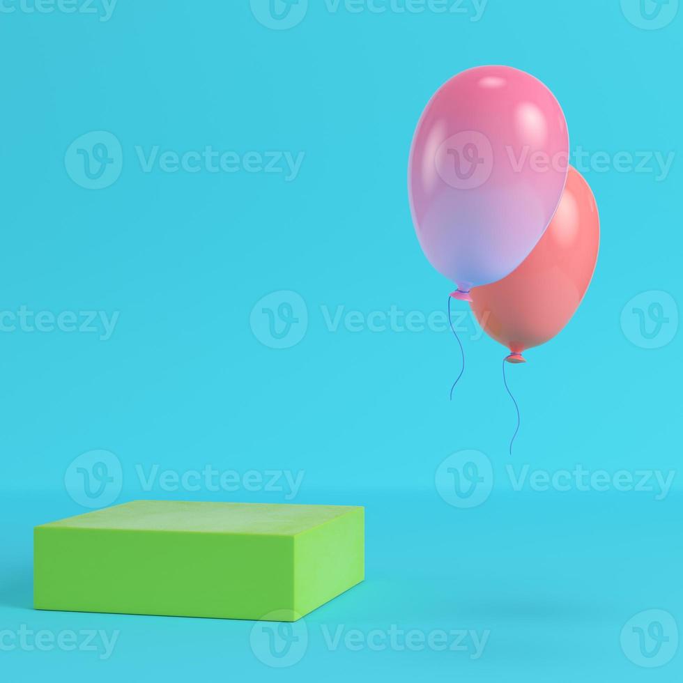 groene doos met twee vliegende ballonnen op felblauwe achtergrond in pastelkleuren foto