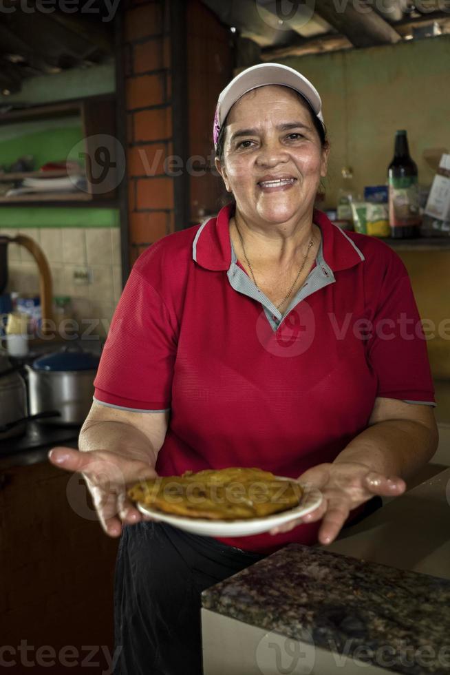 vrouwelijke chef laat ons een vers gemaakte omelet zien. foto