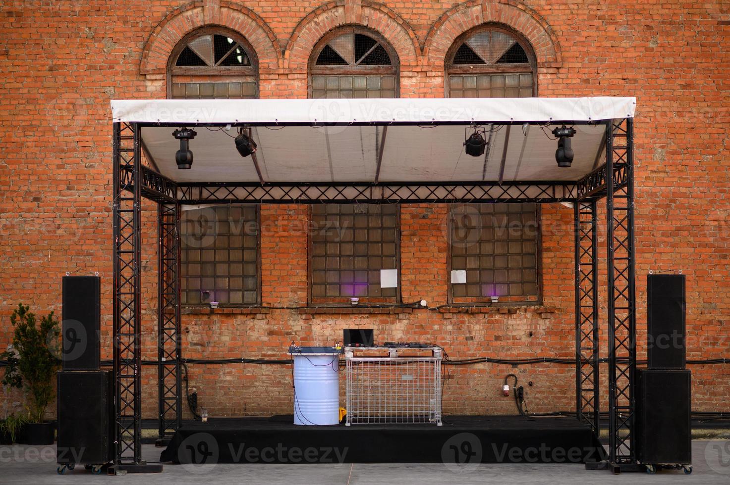 lege dj booth tegen een bakstenen muur. feest in een gesloten fabriek foto