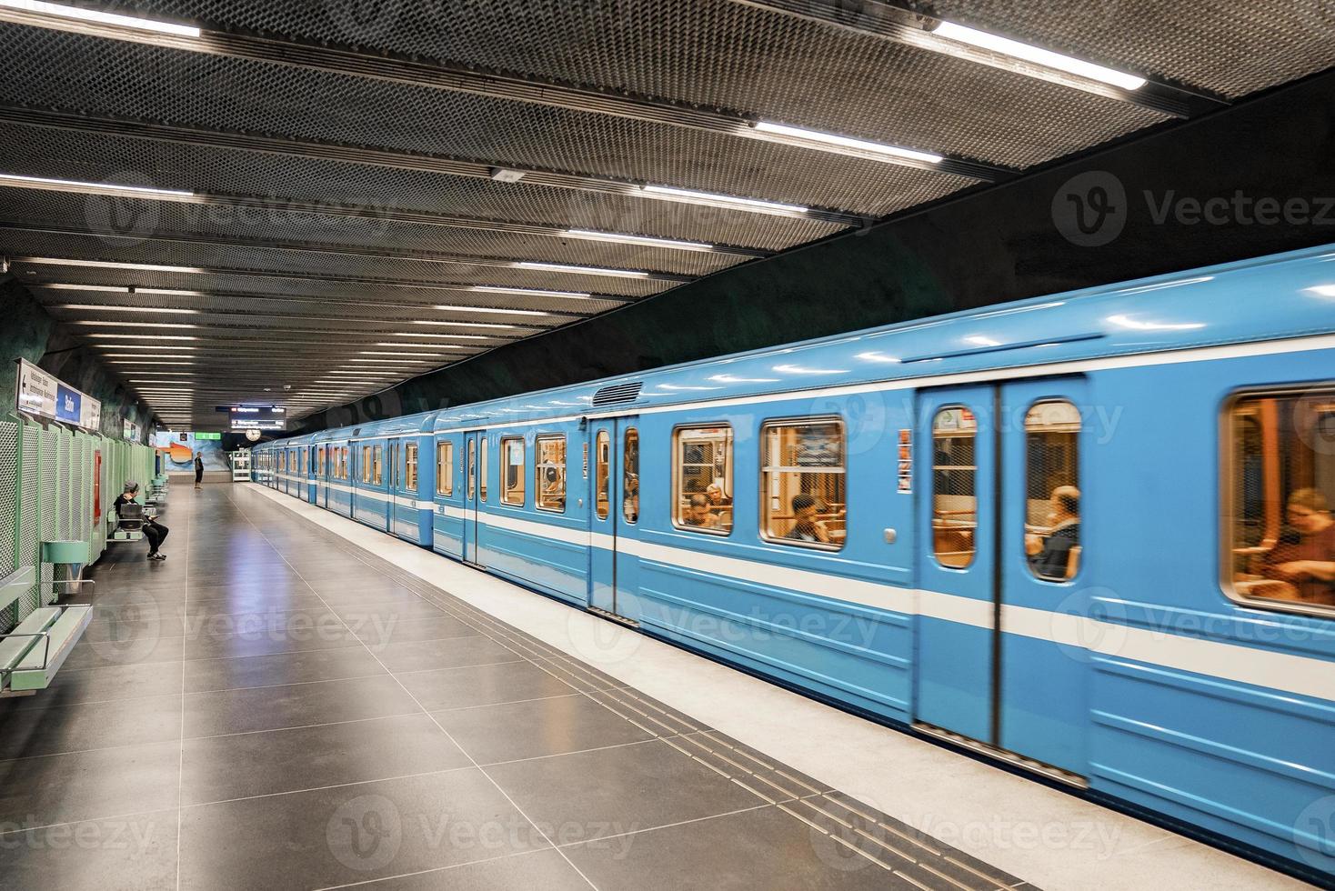 passagiers die in een blauwe trein reisden, kwamen aan bij de metro van het stadionstation in de stad foto