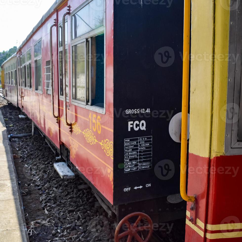 speelgoedtrein die zich op berghellingen beweegt, prachtig uitzicht, een zijberg, een zijvallei die zich op een spoorlijn naar de heuvel beweegt, tussen groen natuurlijk bos. speelgoedtrein van kalka naar shimla in india foto