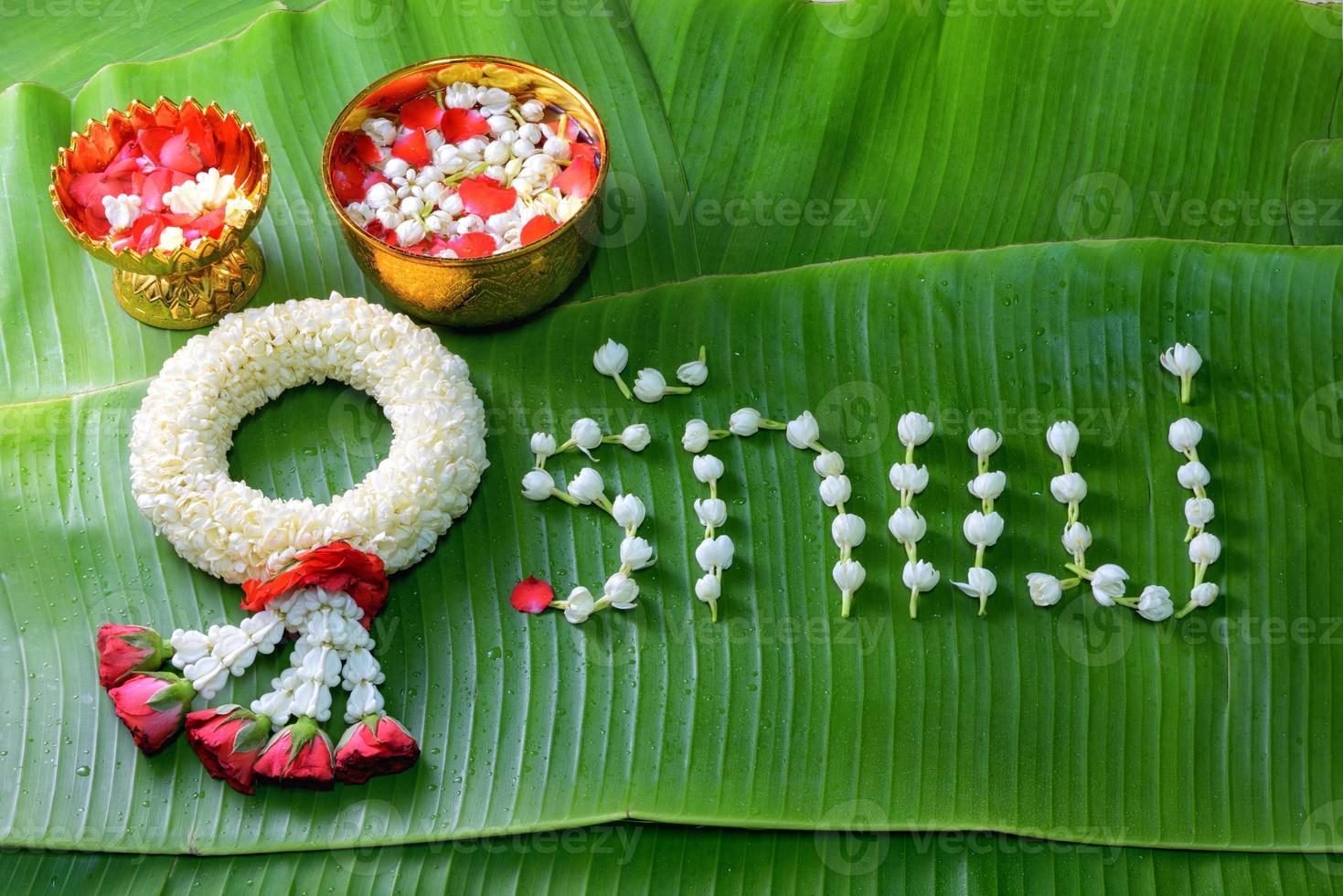 Thaise traditionele jasmijnslinger. symbool van moederdag in thailand op bananenblad met liefdesmoeder in thais woord. foto