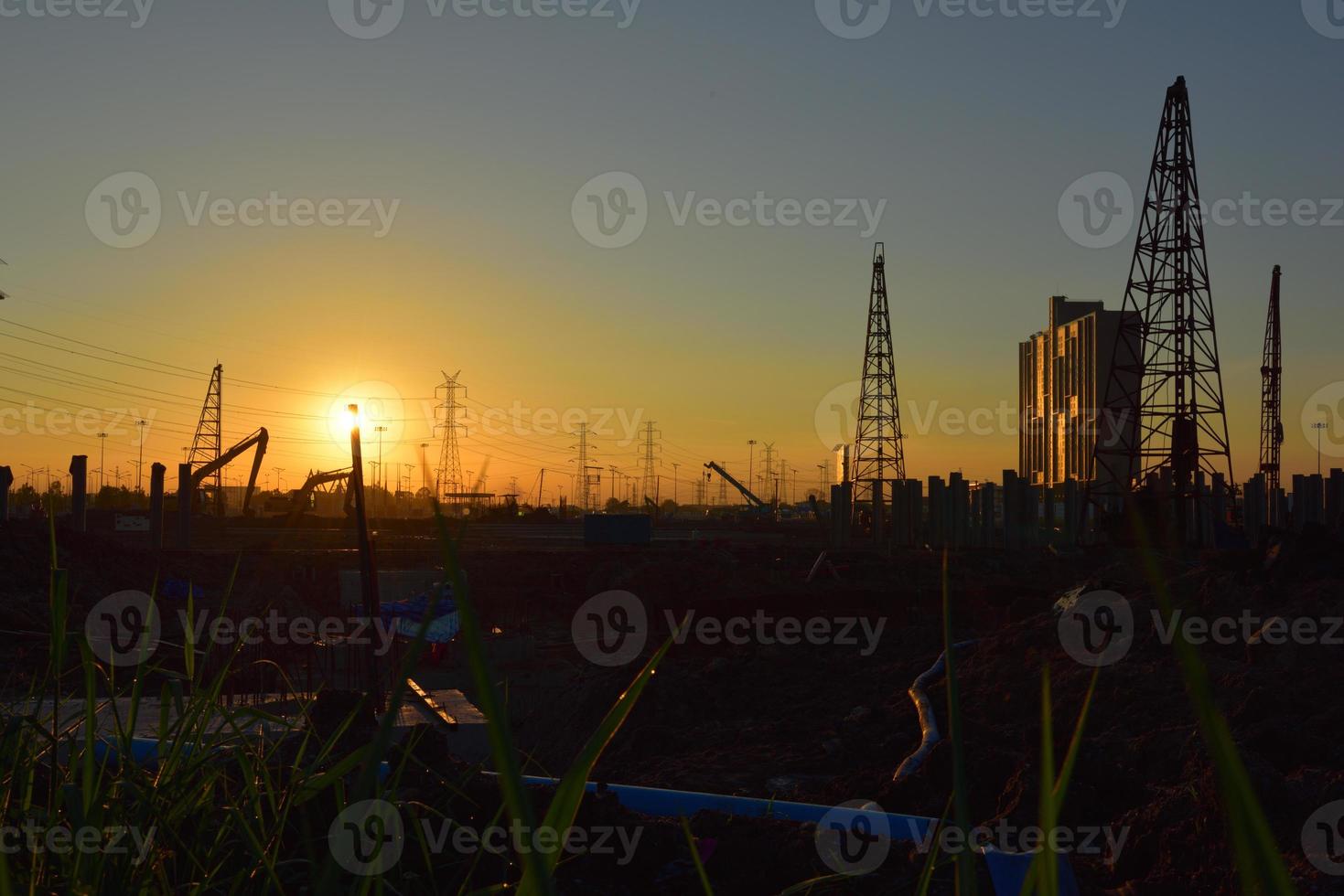 bouwplaats en elektrische paal met zonsopganghemel foto