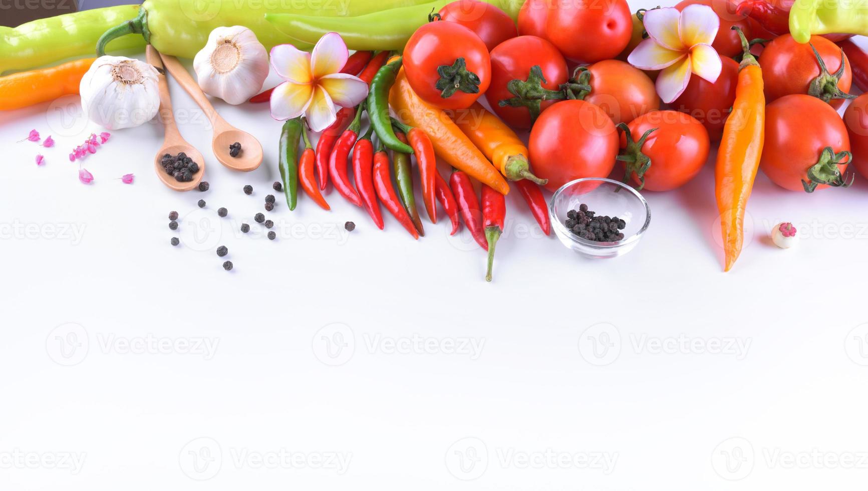 aziatische ingrediënten eten verse kruiden plantaardige tomaat, chili, knoflook, peper, plumeria bovenaanzicht met ruimte voor tekst. foto