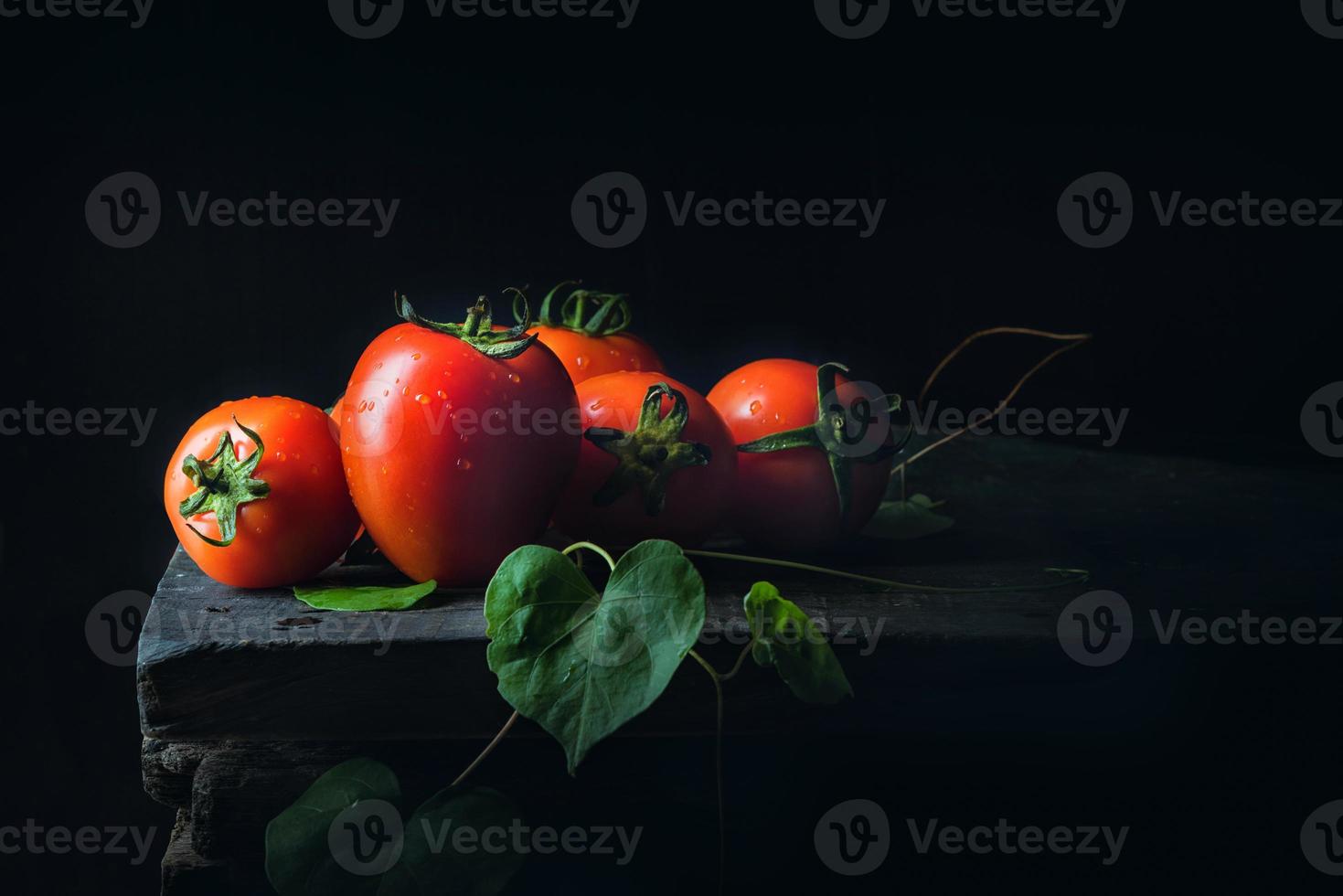 tomaat groente en groen blad op oude donkere houten vloer antiek zwart foto