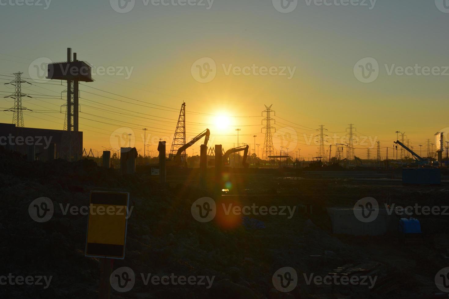 bouwplaats en elektrische paal met zonsopganghemel foto