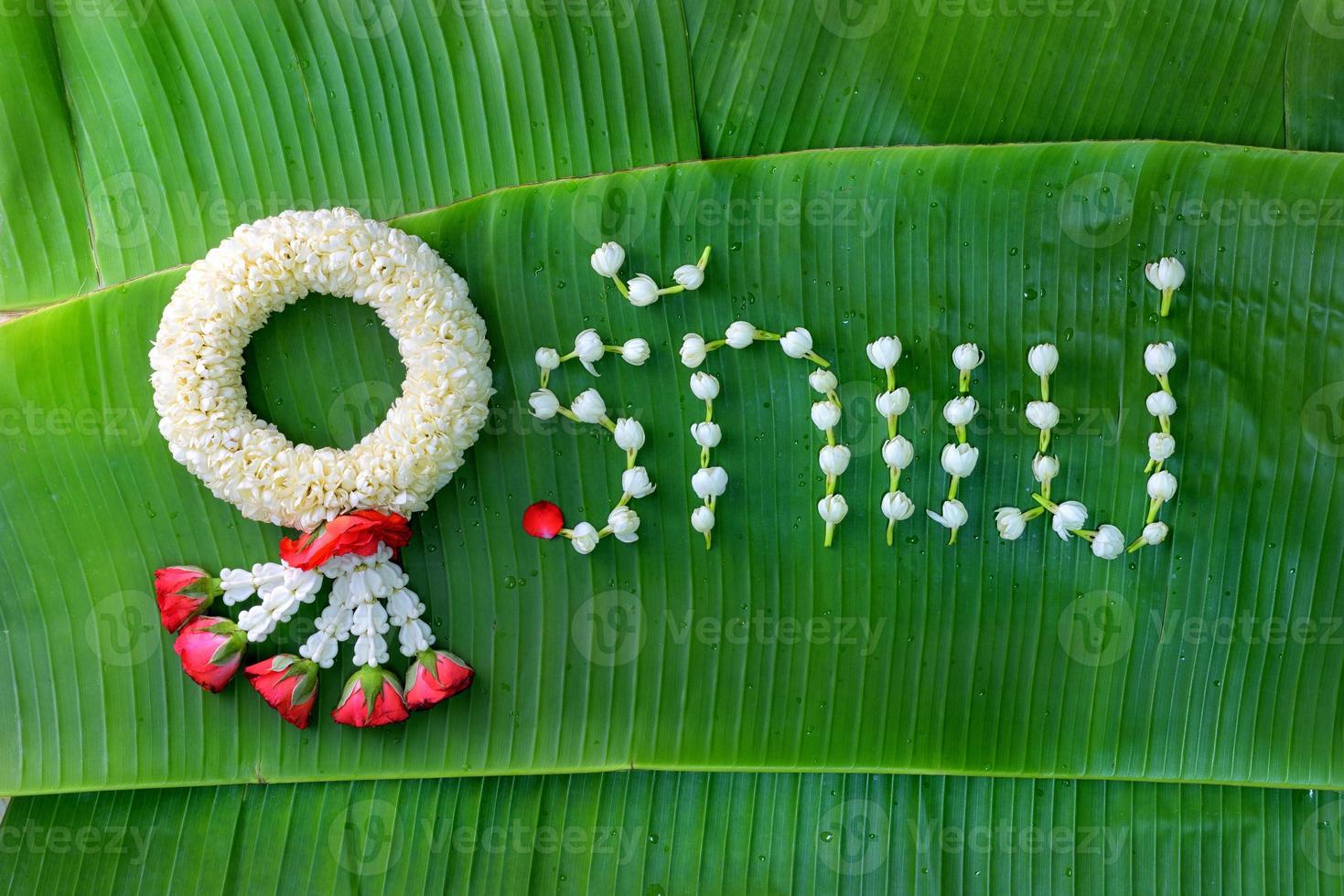 Thaise traditionele jasmijnslinger. symbool van moederdag in thailand op bananenblad met liefdesmoeder in thais woord. foto