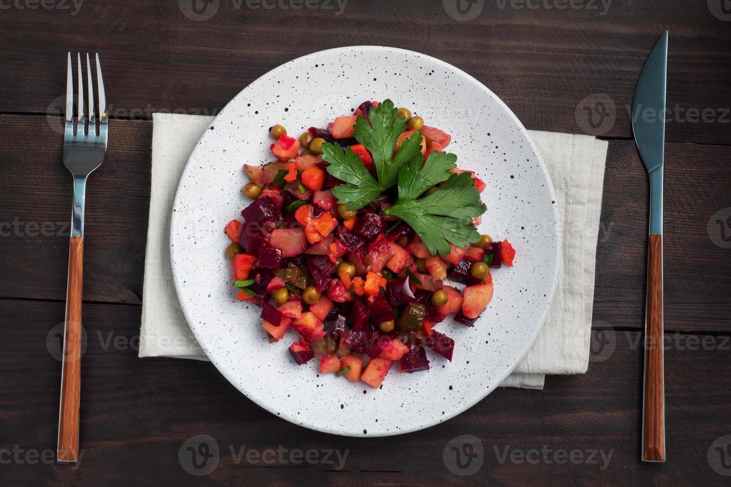 vinaigrette met rode biet en gekookte groenten, traditionele Russische zelfgemaakte salade. donkere houten achtergrond, kopieer ruimte. foto