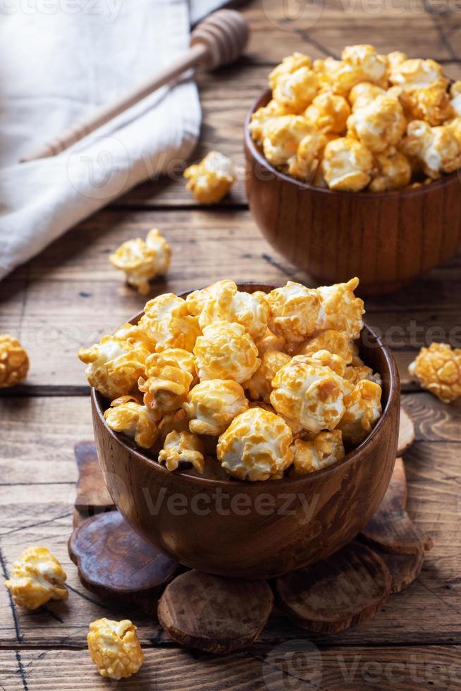 popcorn in karamelglazuur in houten platen op een rustieke tafel. foto