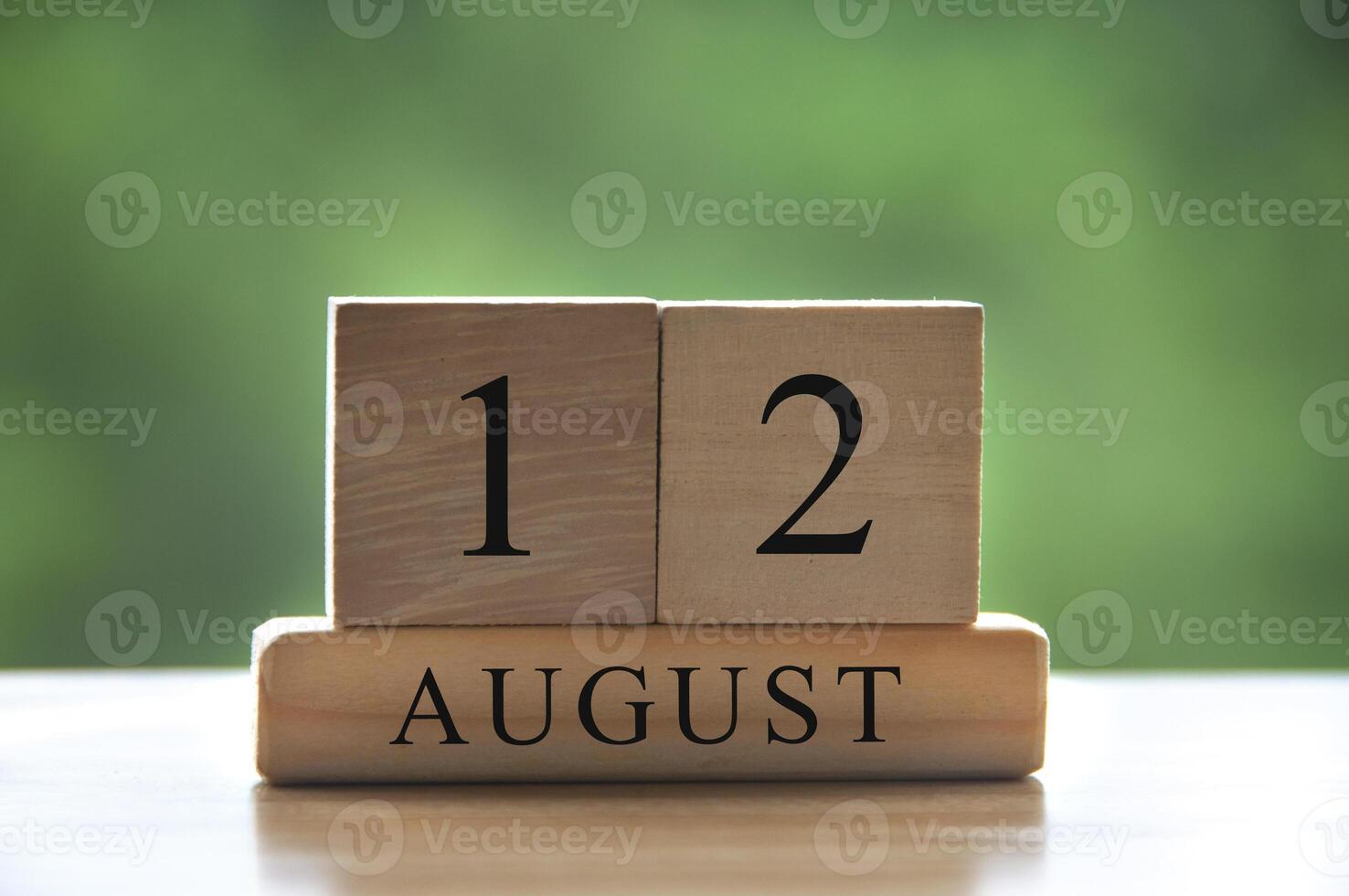 12 augustus kalenderdatum tekst op houten blokken met wazig park als achtergrond. kopieer ruimte en kalenderconcept foto