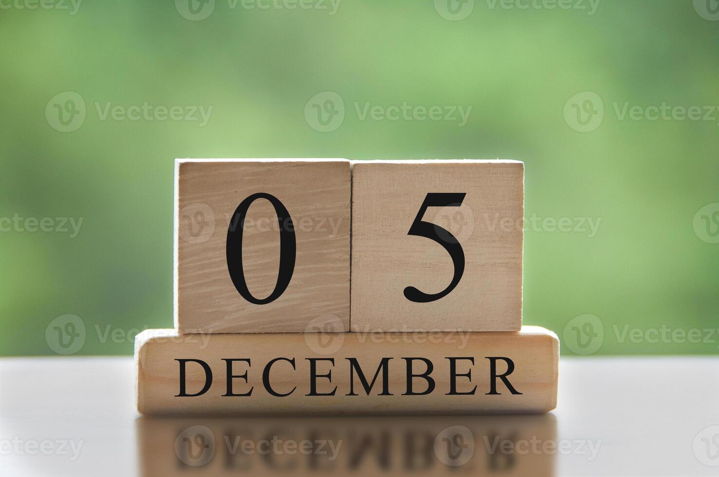 5 december tekst op houten blokken met vage aardachtergrond. kalender concept foto