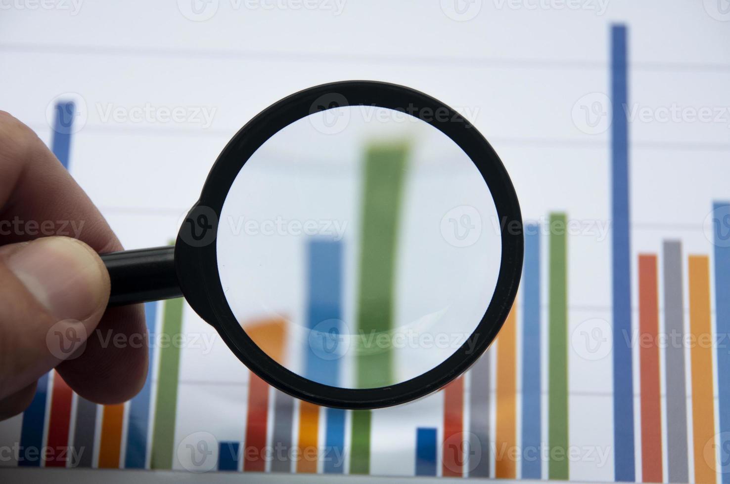 analyse van gegevens, grafiek en grafieken met behulp van vergrootglas. bedrijfsfinanciën concept foto