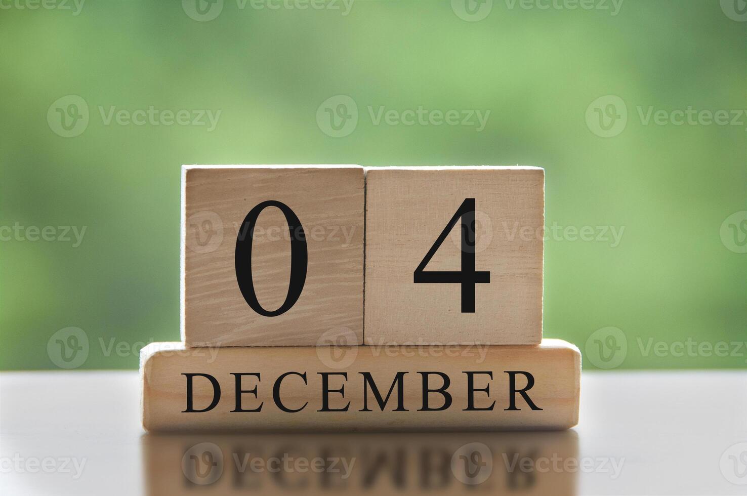 4 december tekst op houten blokken met vage aardachtergrond. kalender concept foto