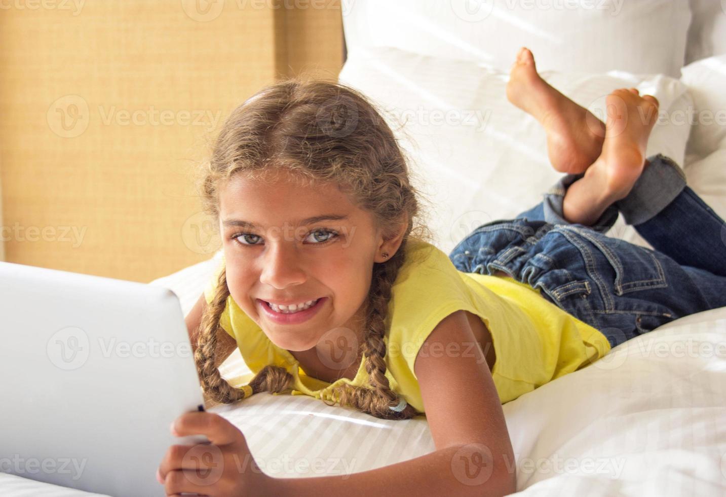 gelukkig meisje spelen op een tablet foto