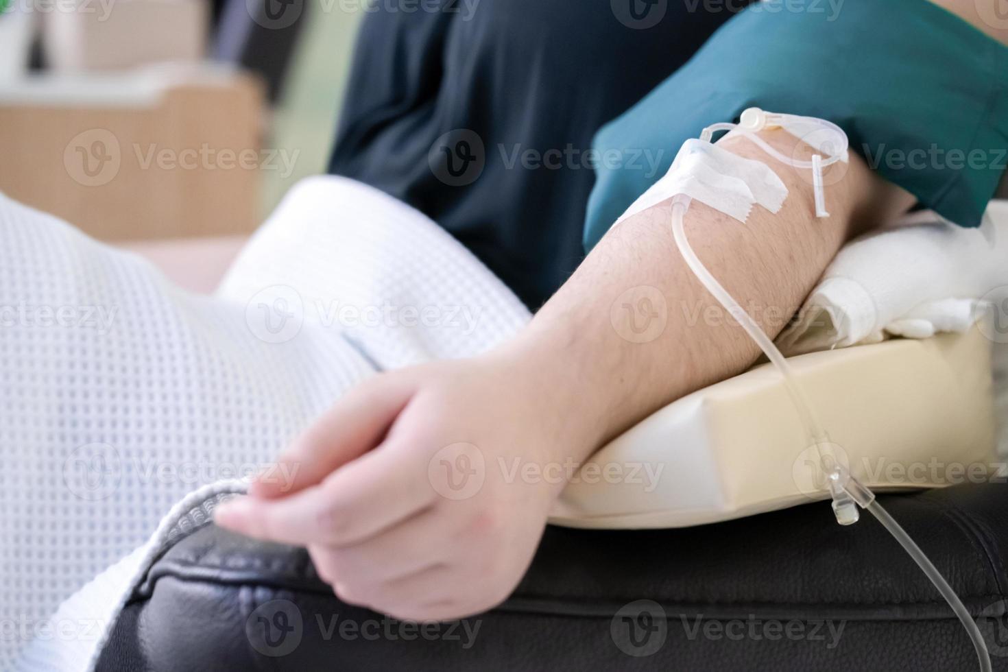 close-up tot aziatische arm die vitamine ontvangt van de kliniek voor vrouwenzorg. foto