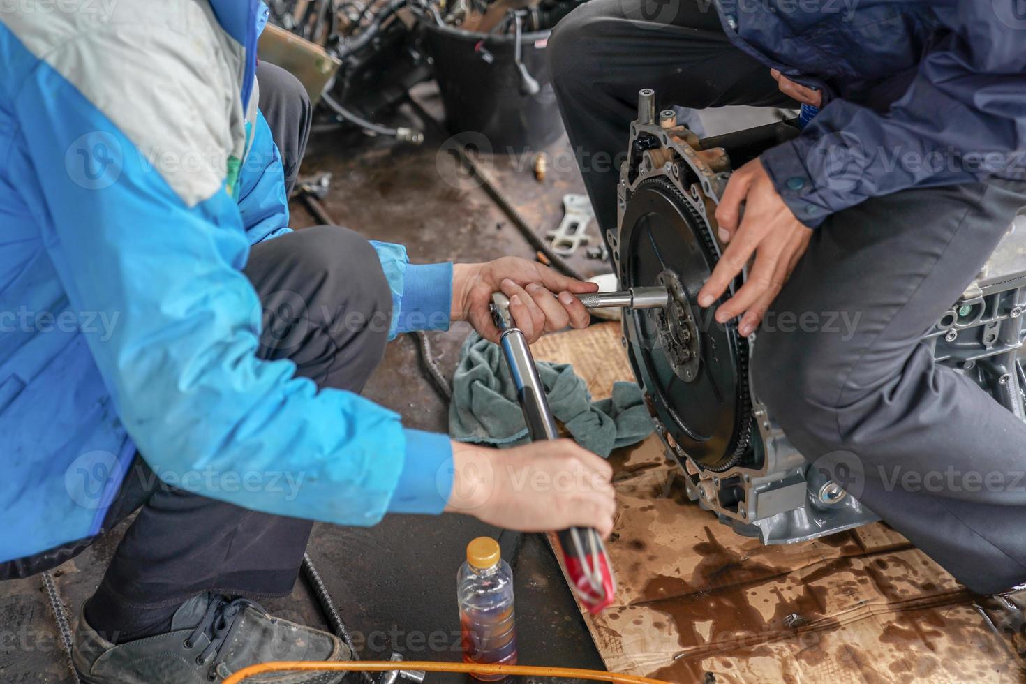 2 monteurs proberen de bootmotor te repareren en af te stellen. foto