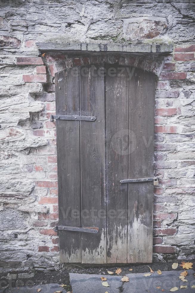 oude houten deur in een bakstenen muur foto