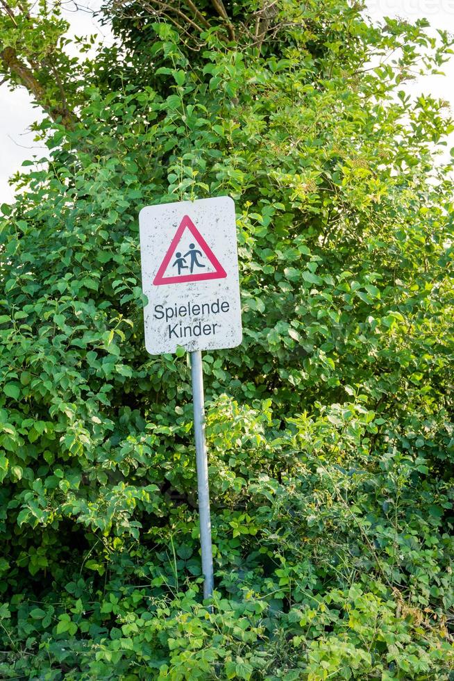 een waarschuwingsbord met de Duitse tekst spelende kinderen foto