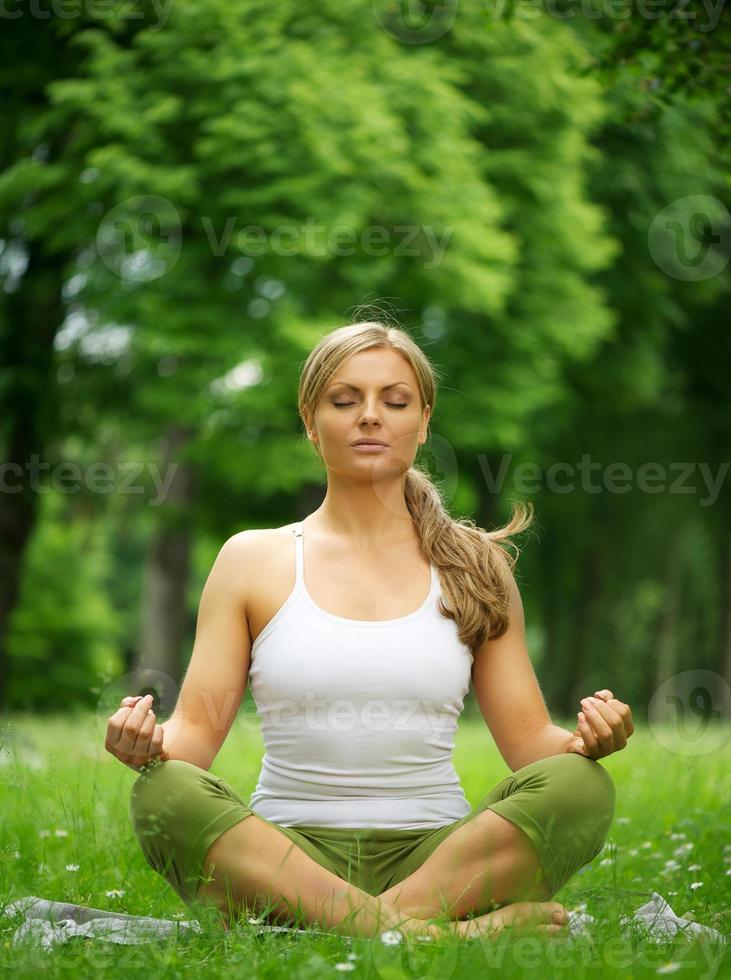 vrouw zitten in yoga pose meditatie buitenshuis foto