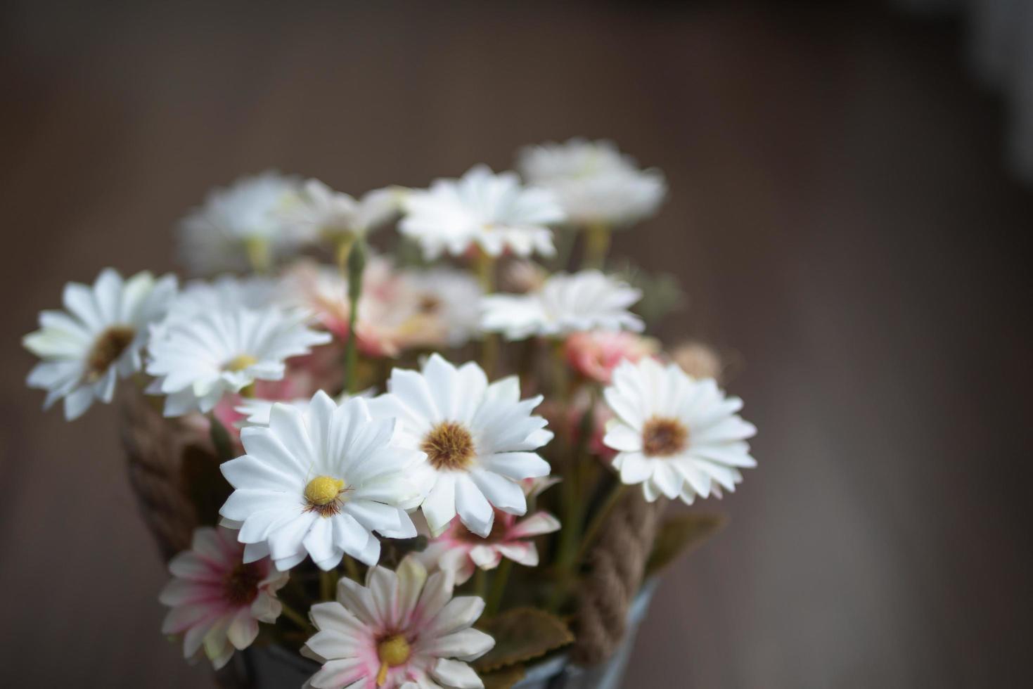 witte en roze bloemen op de houten tafel met onscherpe achtergrond foto