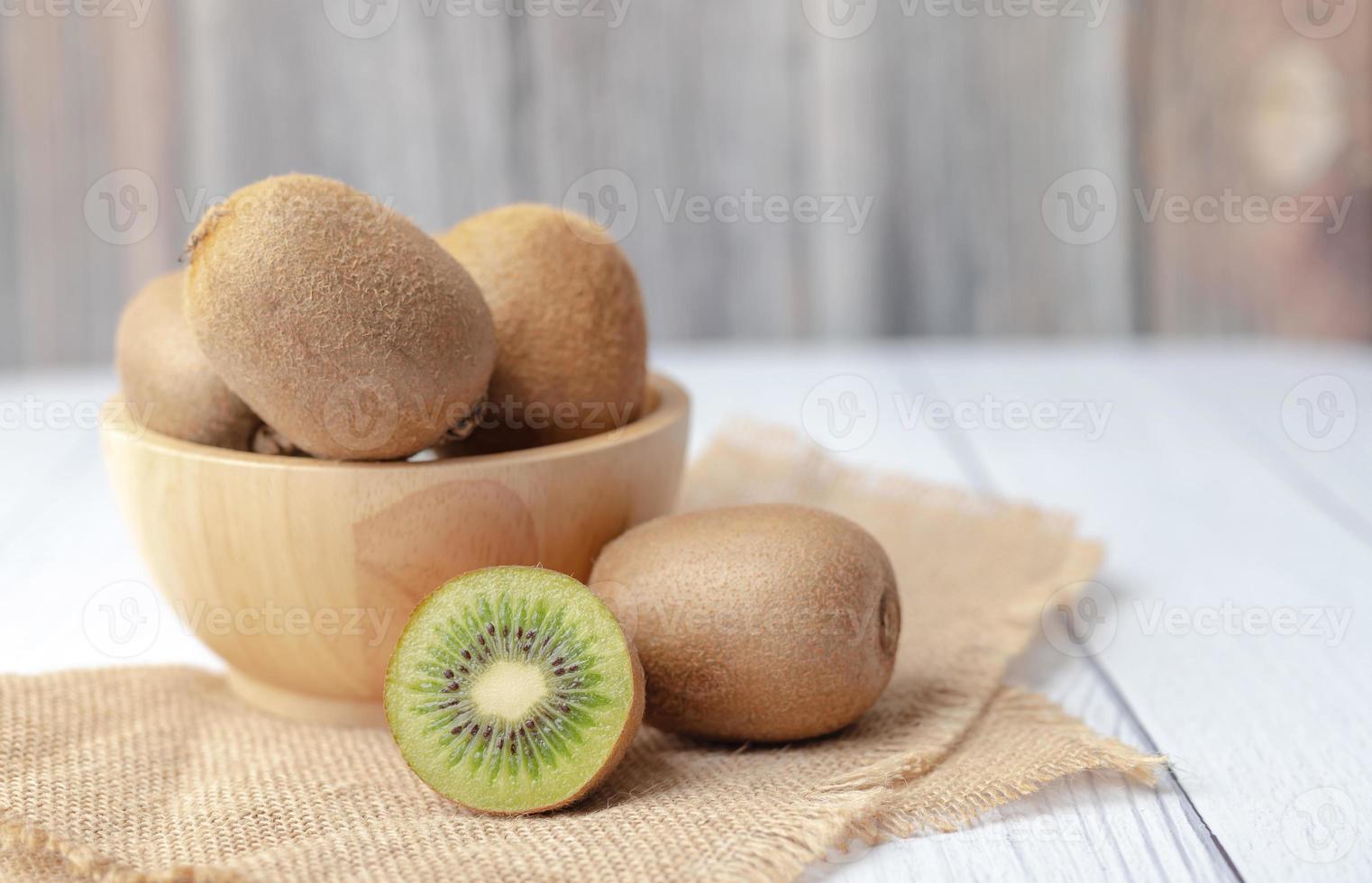 kiwi's in een kom op de houten tafel foto