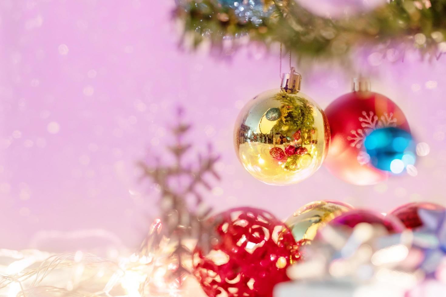 kerstballen en vage sneeuwvlok hangend aan de tak van de dennen foto