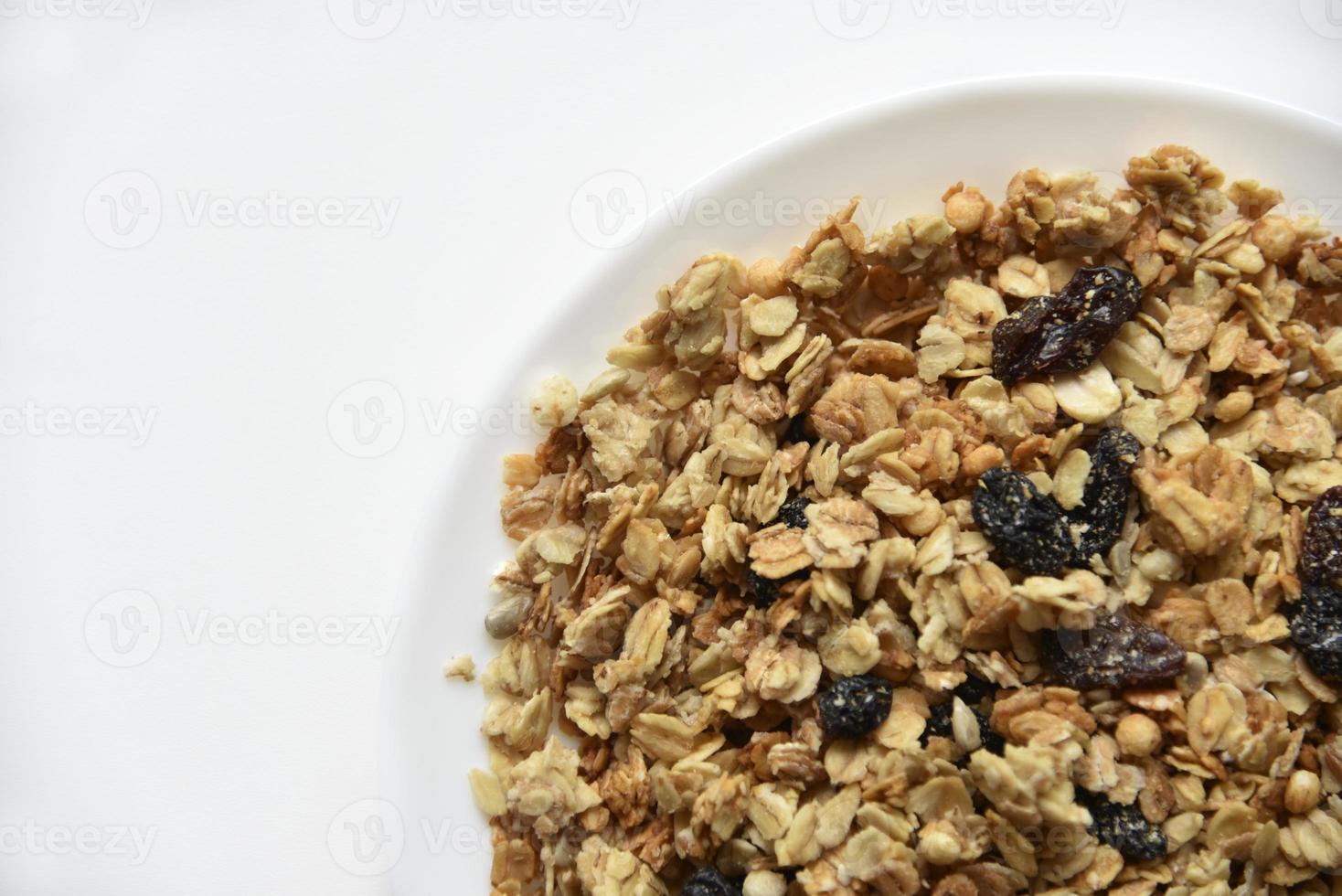 muesli met noten en rozijnen op een witte plaat foto