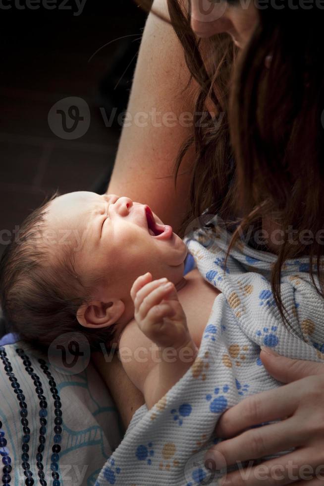 moeder wiegen geeuwen pasgeboren baby foto
