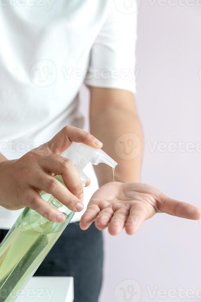 de vrouw kneep de alcoholgel in een pompflesje in de handpalm foto