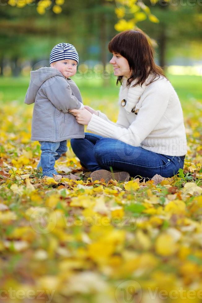 jonge moeder met haar kleine baby in het najaar park foto