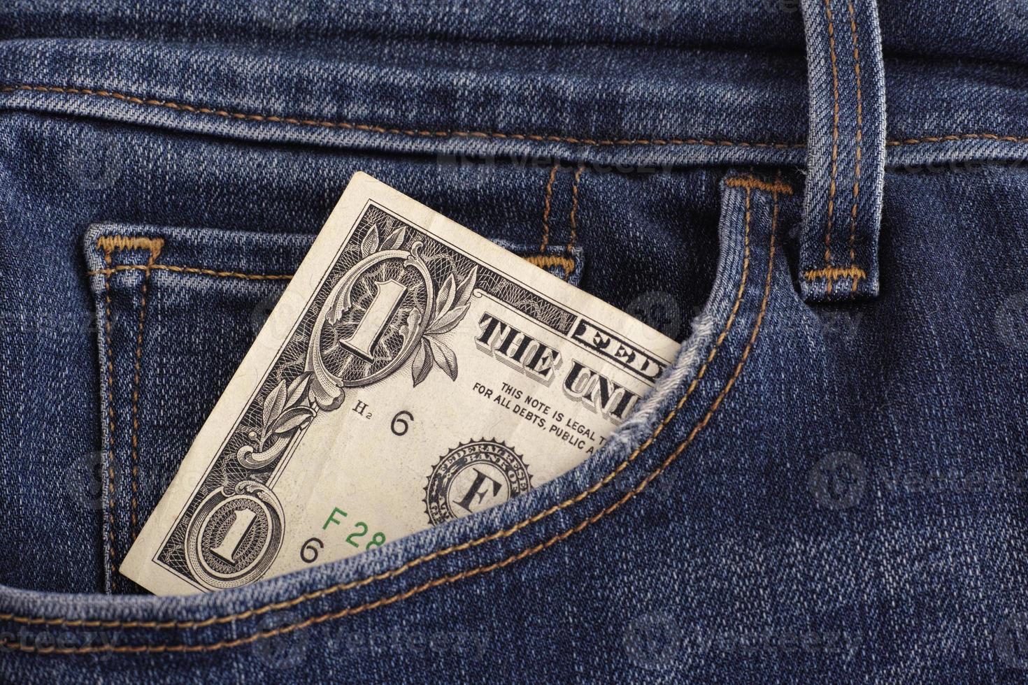 een dollarbiljet in een zak spijkerbroek foto